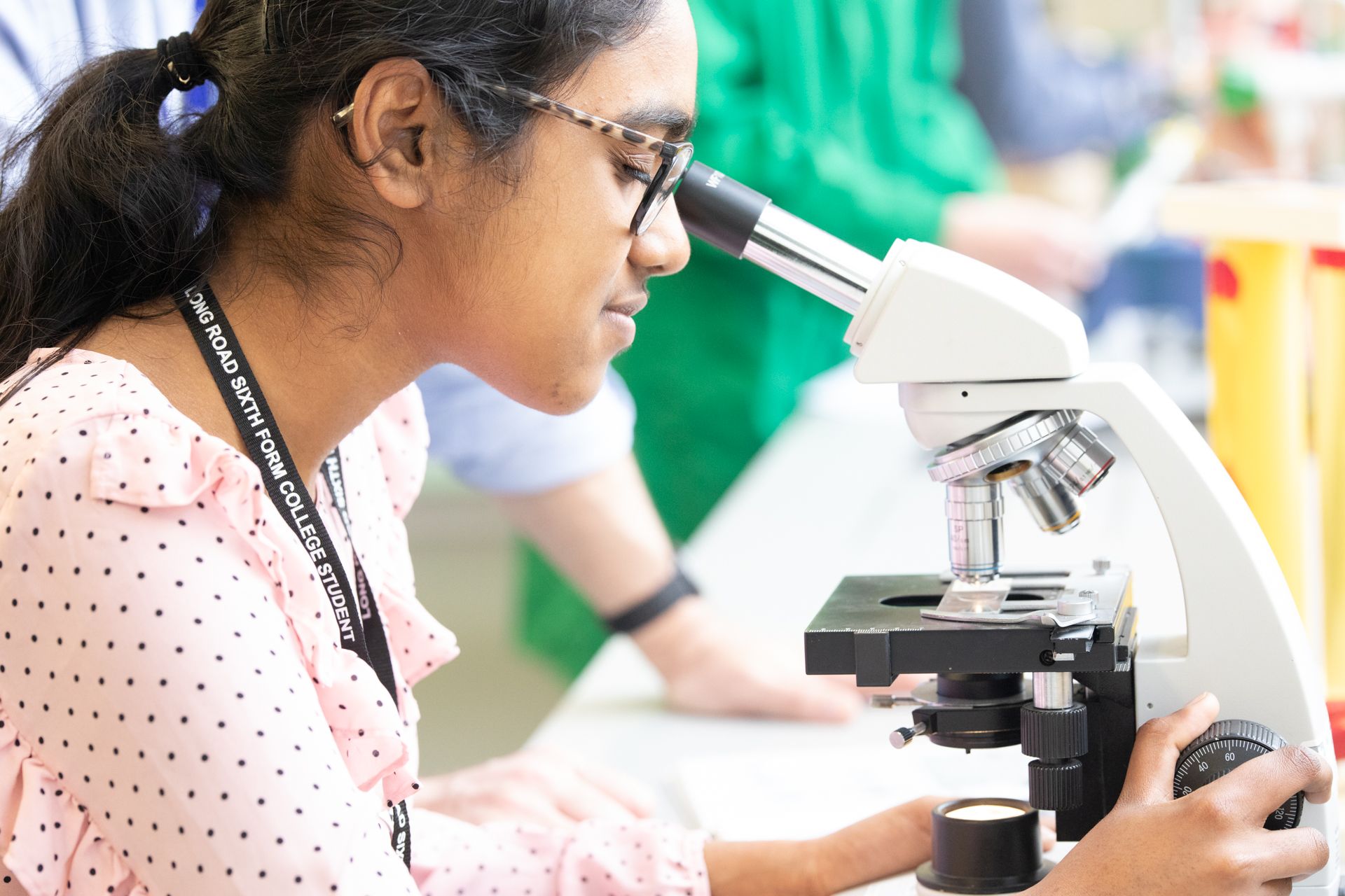 female student looking into a microscope