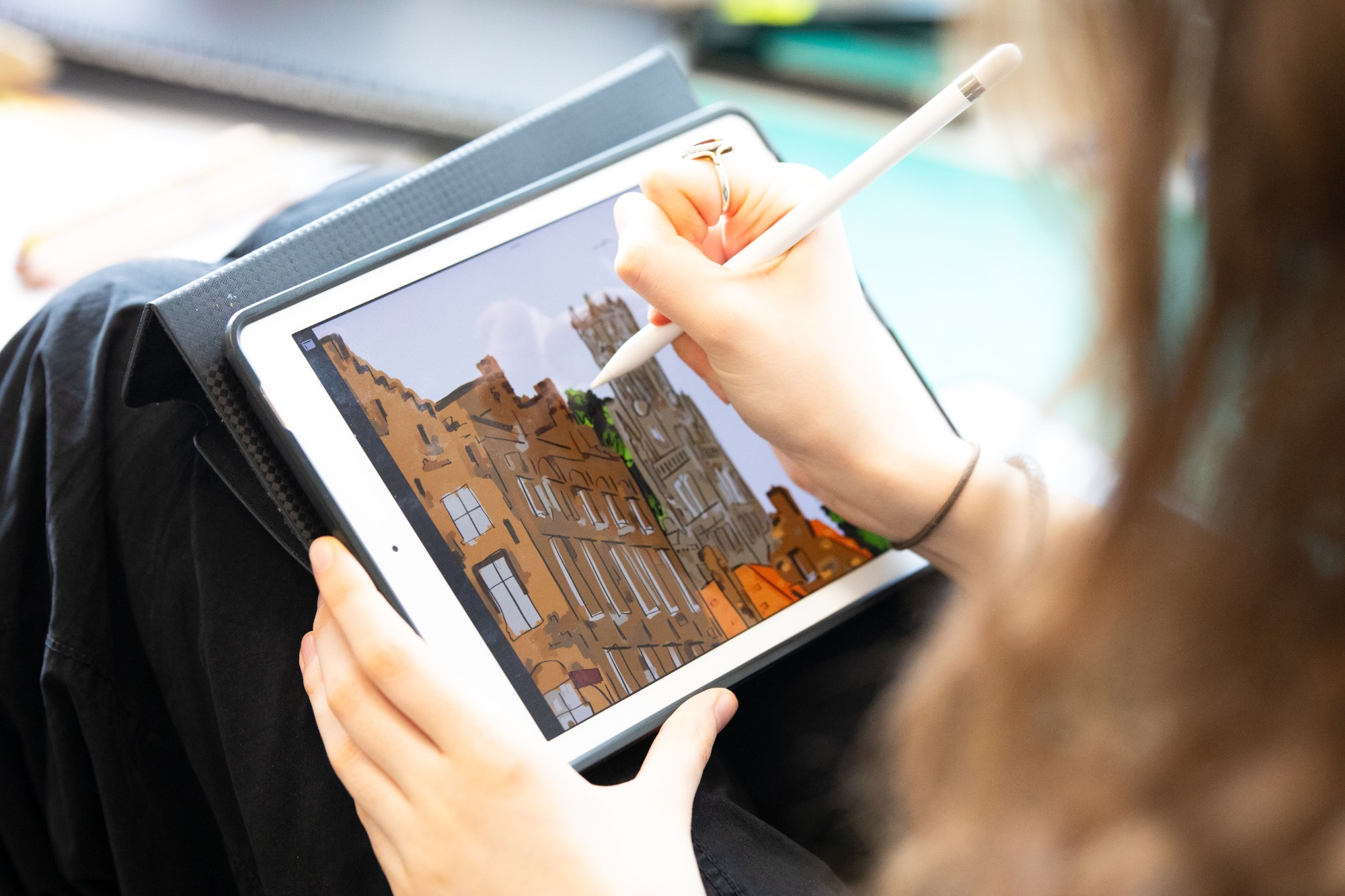 student drawing buildings of Cambridge University on an ipad